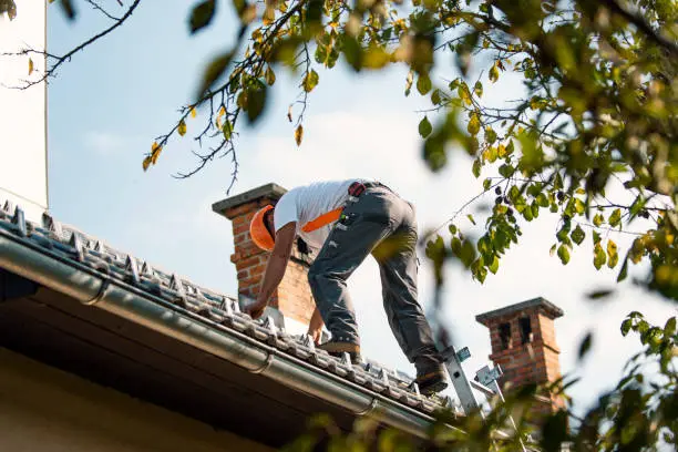 Skilled roofer inspecting flashing, shingles, and roof penetrations for precise repair planning
