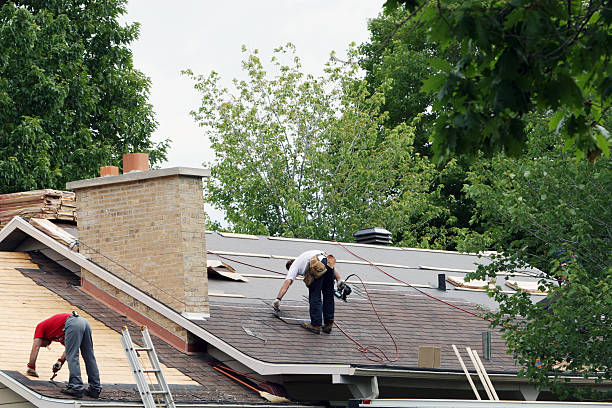 Experienced roofer inspecting storm-worn shingles and flashing for precise repair recommendations