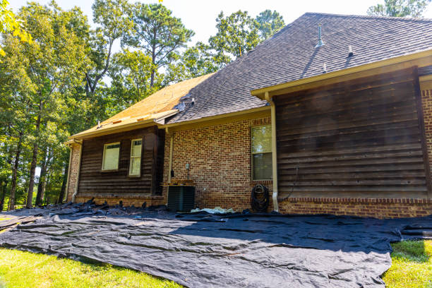 Skilled roofer examining roof ventilation and flashing details during replacement assessment