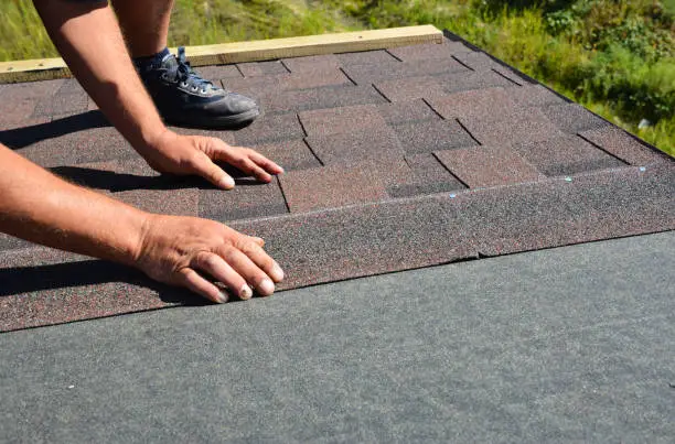 Roofing crew replacing worn shingles on an older El Reno residential home
